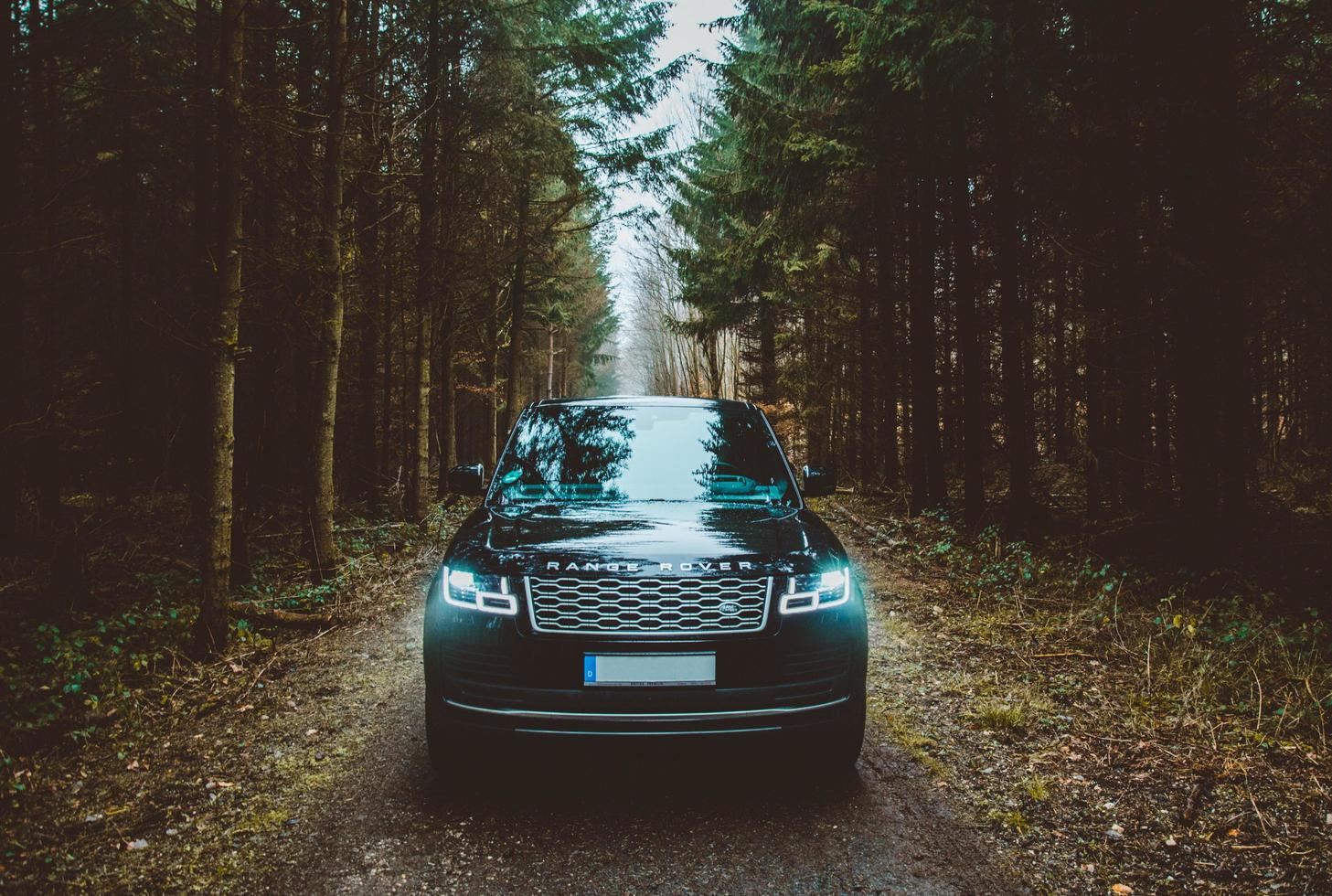 mallorca, espanha, 2020 - land rover range rover suv em uma estrada de terra entre árvores verdes foto