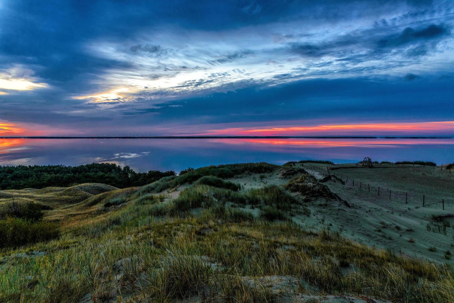 corpo d'água e dunas durante o pôr do sol foto