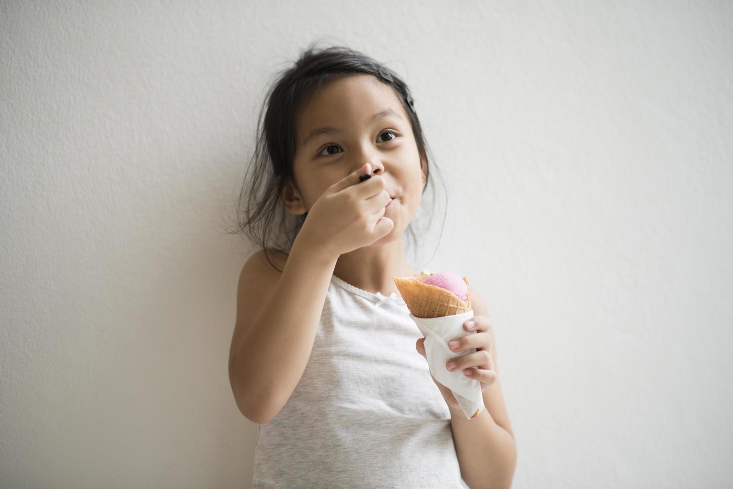 retrato de uma menina tomando sorvete foto