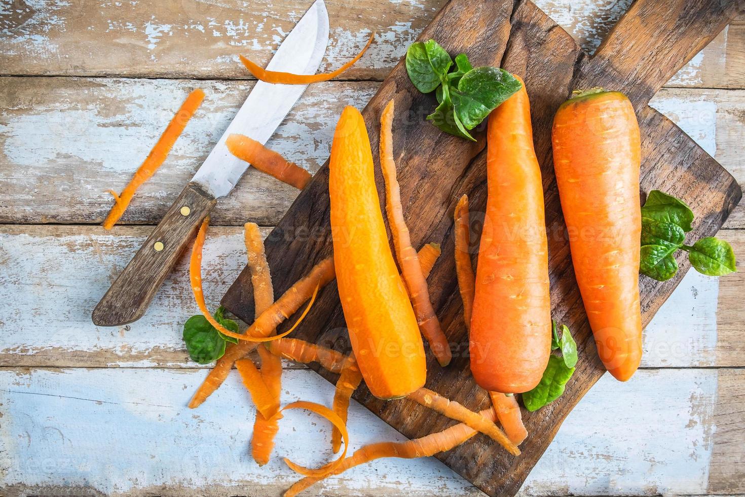 cenouras com uma faca em uma tábua de cortar foto