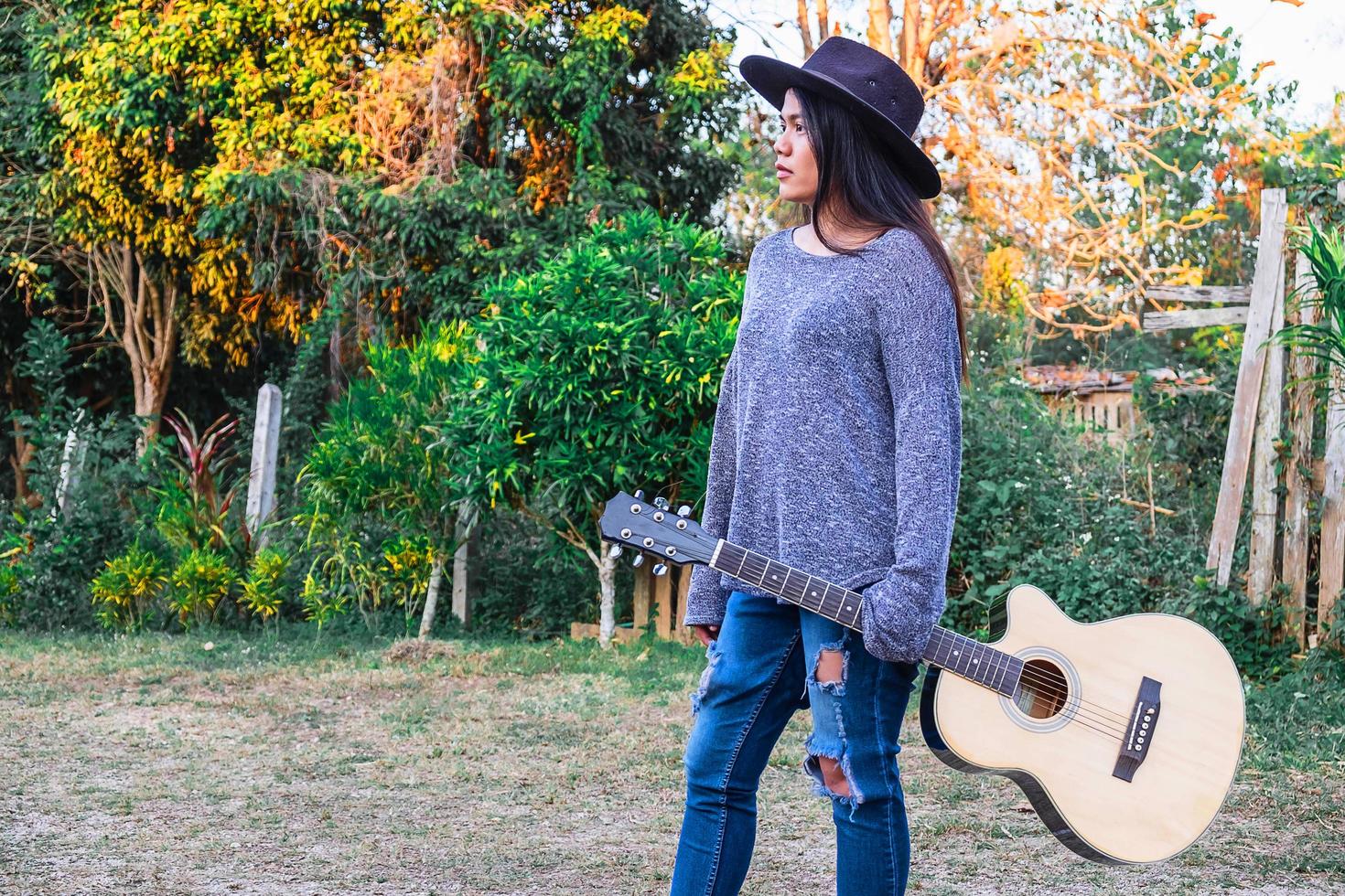 mulher caminhando com um violão foto