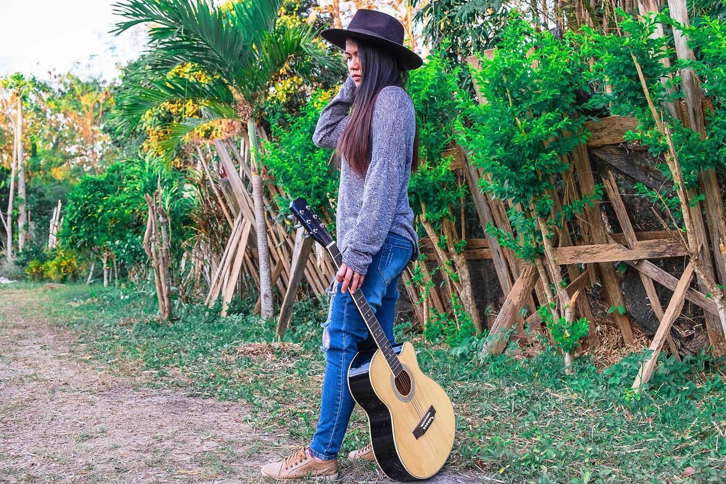 mulher segurando um violão enquanto caminha foto