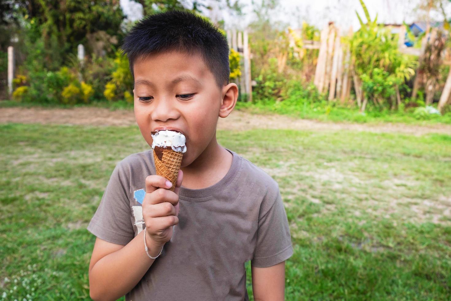 menino tomando sorvete lá fora foto