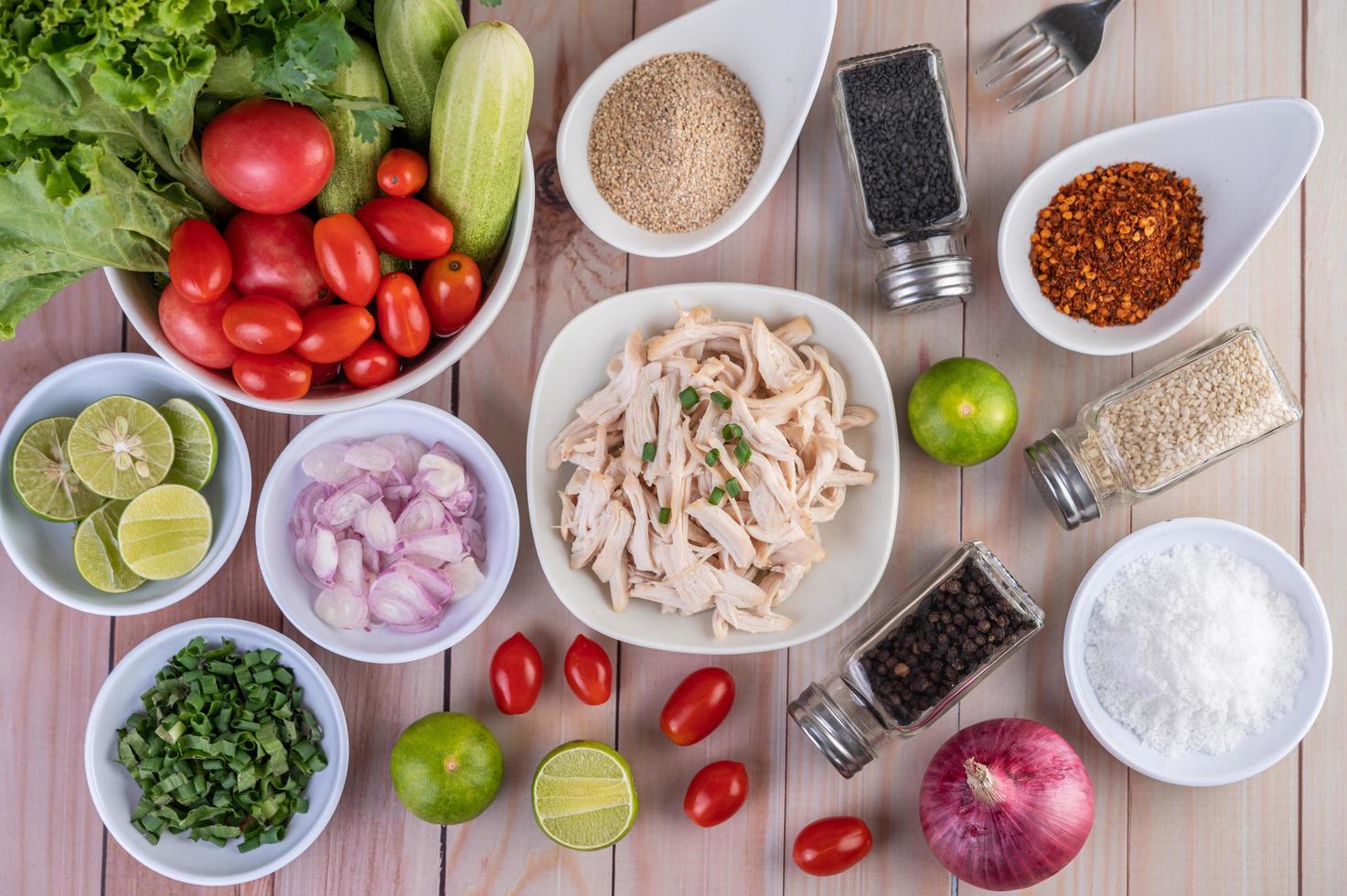 Pedaços de frango cozido com legumes e temperos em uma mesa de madeira foto