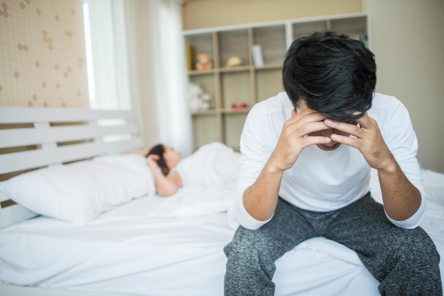 homem chateado na cama após discutir com a namorada foto