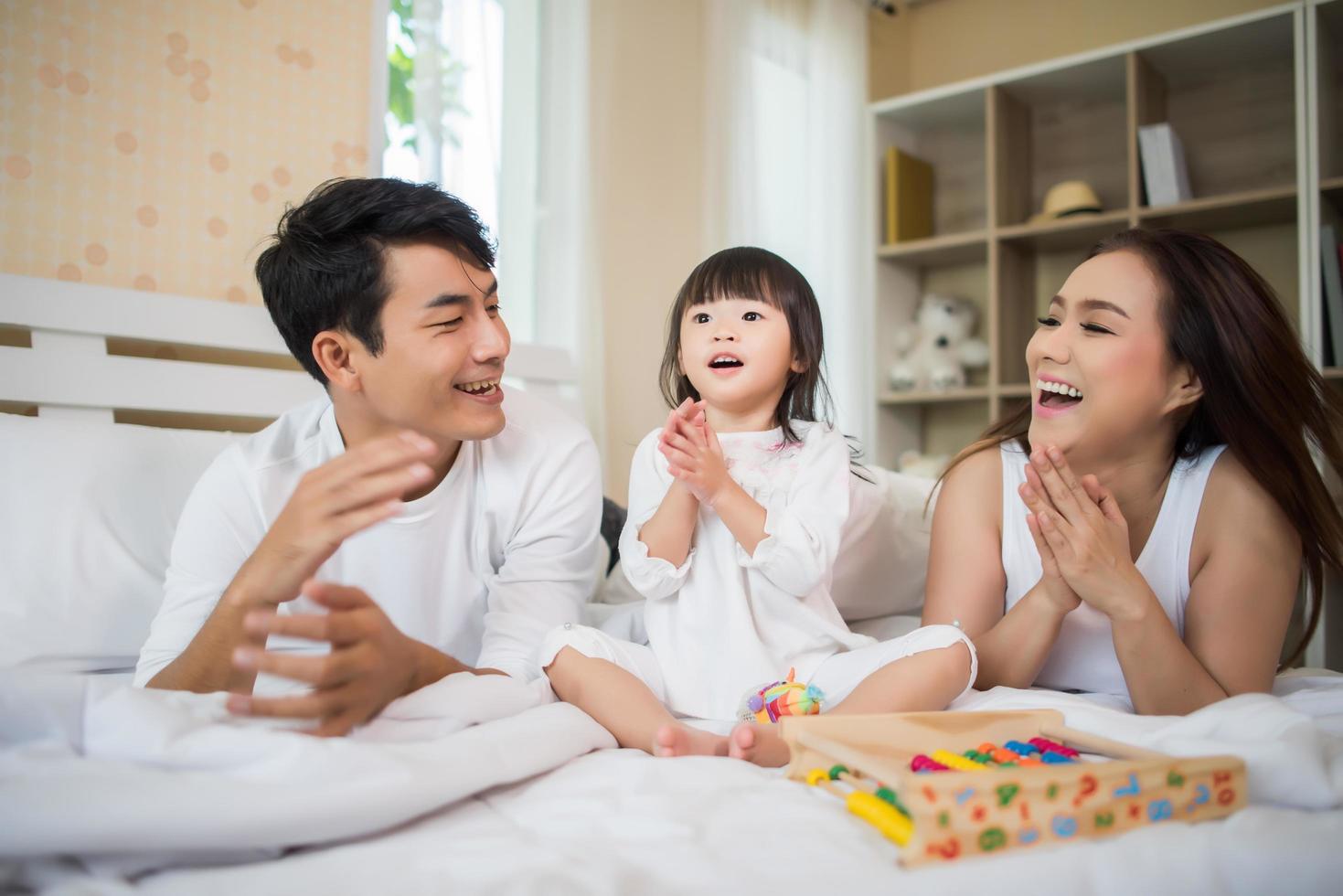 criança feliz com pais brincando em casa foto