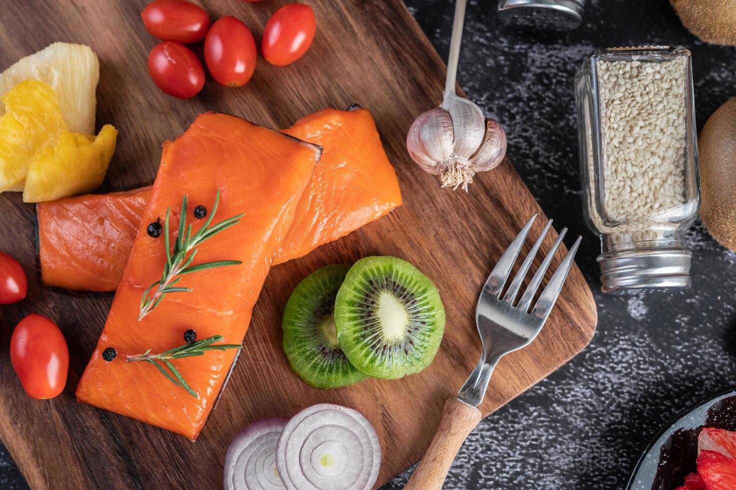 filés de salmão crus com pimenta, kiwi, abacaxi e alecrim foto