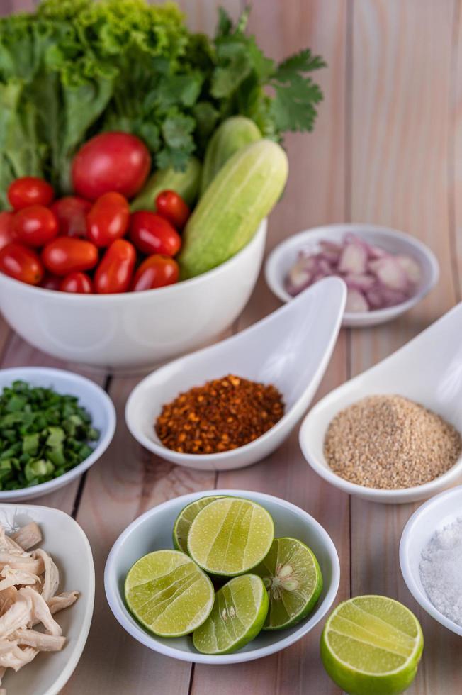 Pedaços de frango cozido com legumes e temperos em uma mesa de madeira foto