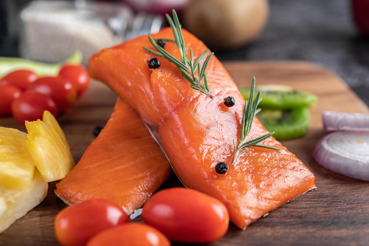 filés de salmão crus com pimenta, kiwi, abacaxi e alecrim foto