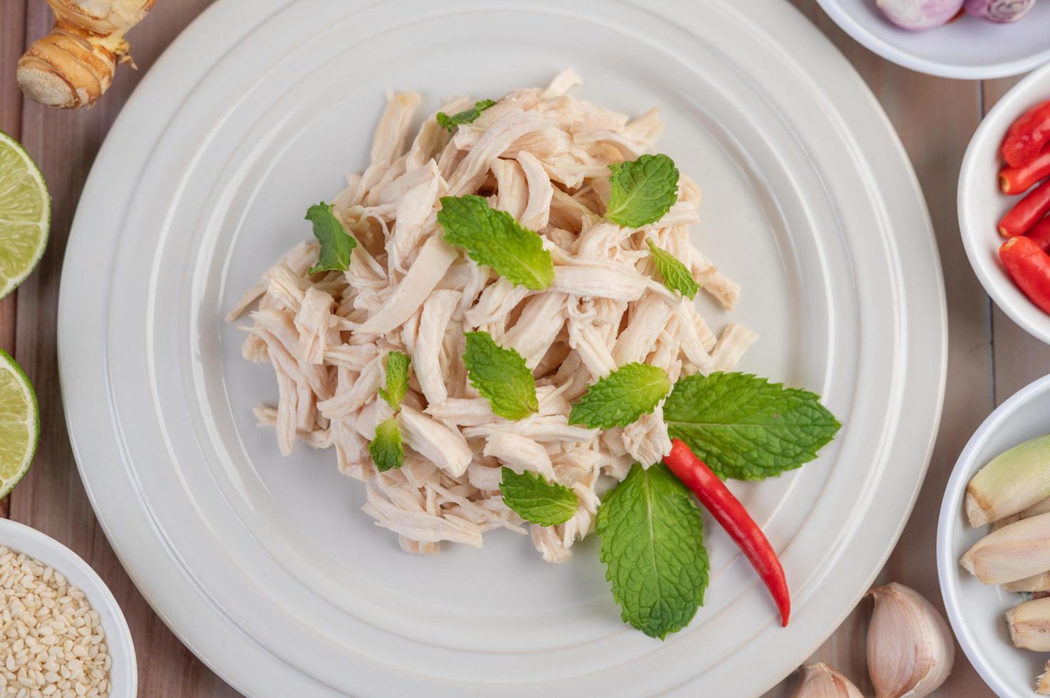 salada de frango em um prato branco com folhas de hortelã foto