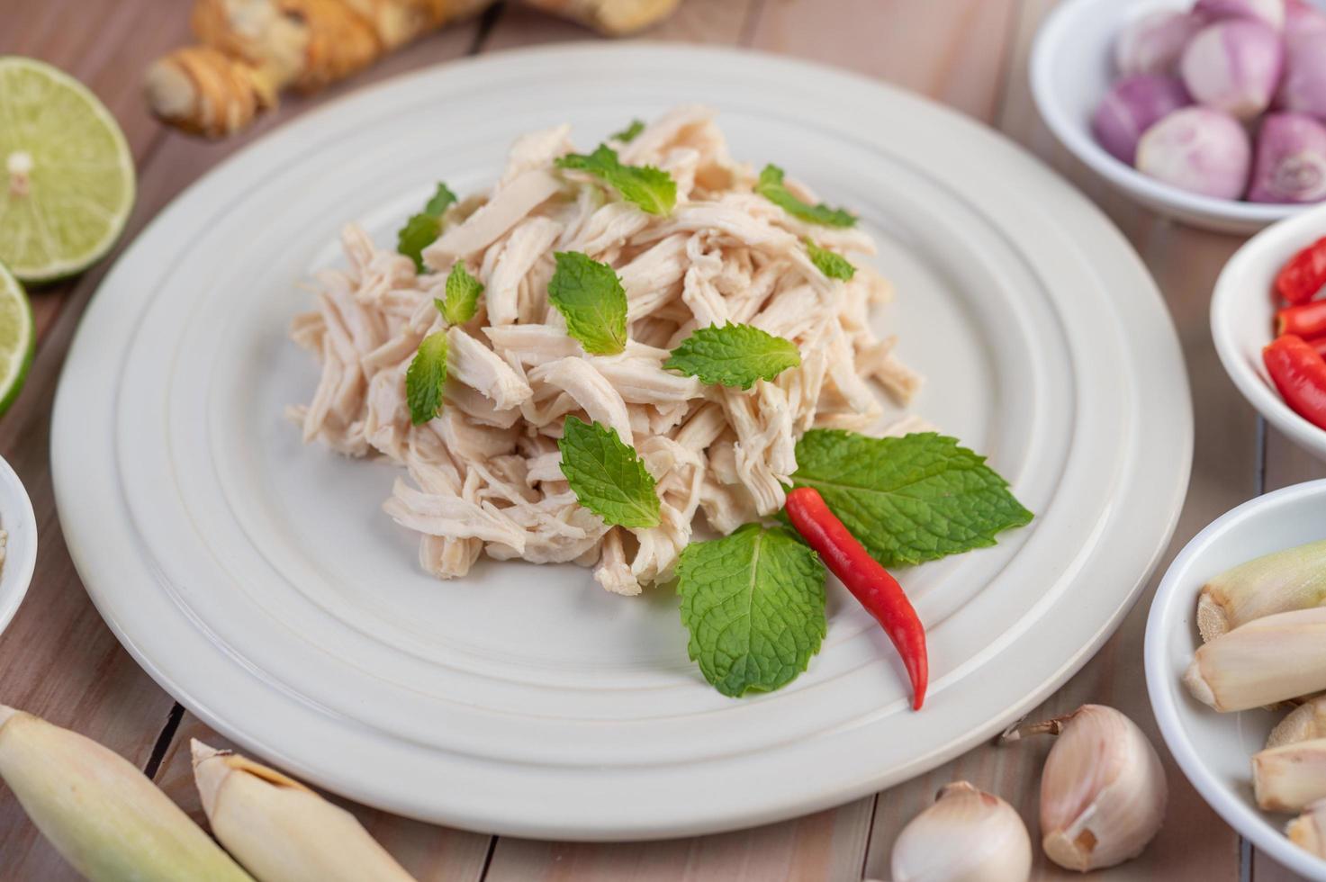 salada de frango em um prato branco com folhas de hortelã foto