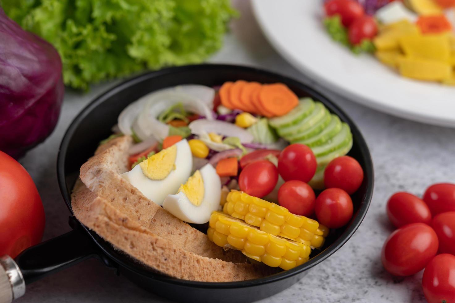 salada de legumes com pão e ovos cozidos foto