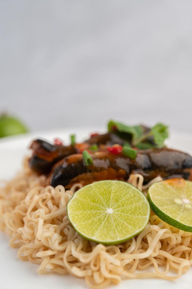 macarrão e peixe enlatado em um prato branco foto