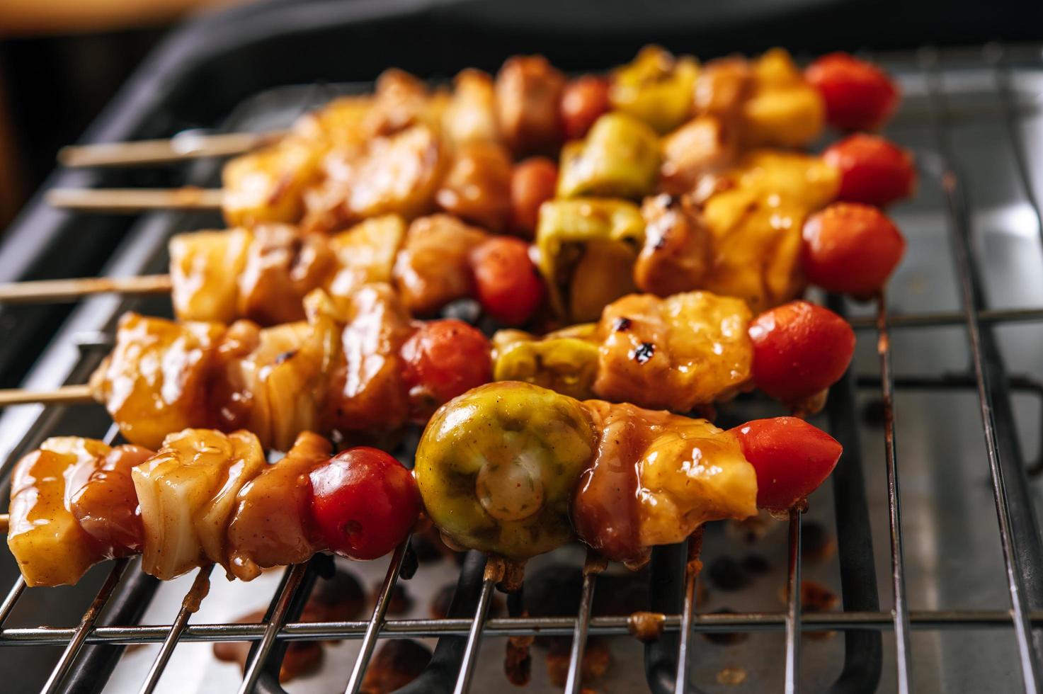 churrasqueira com variedade de carnes, tomate e pimentão foto