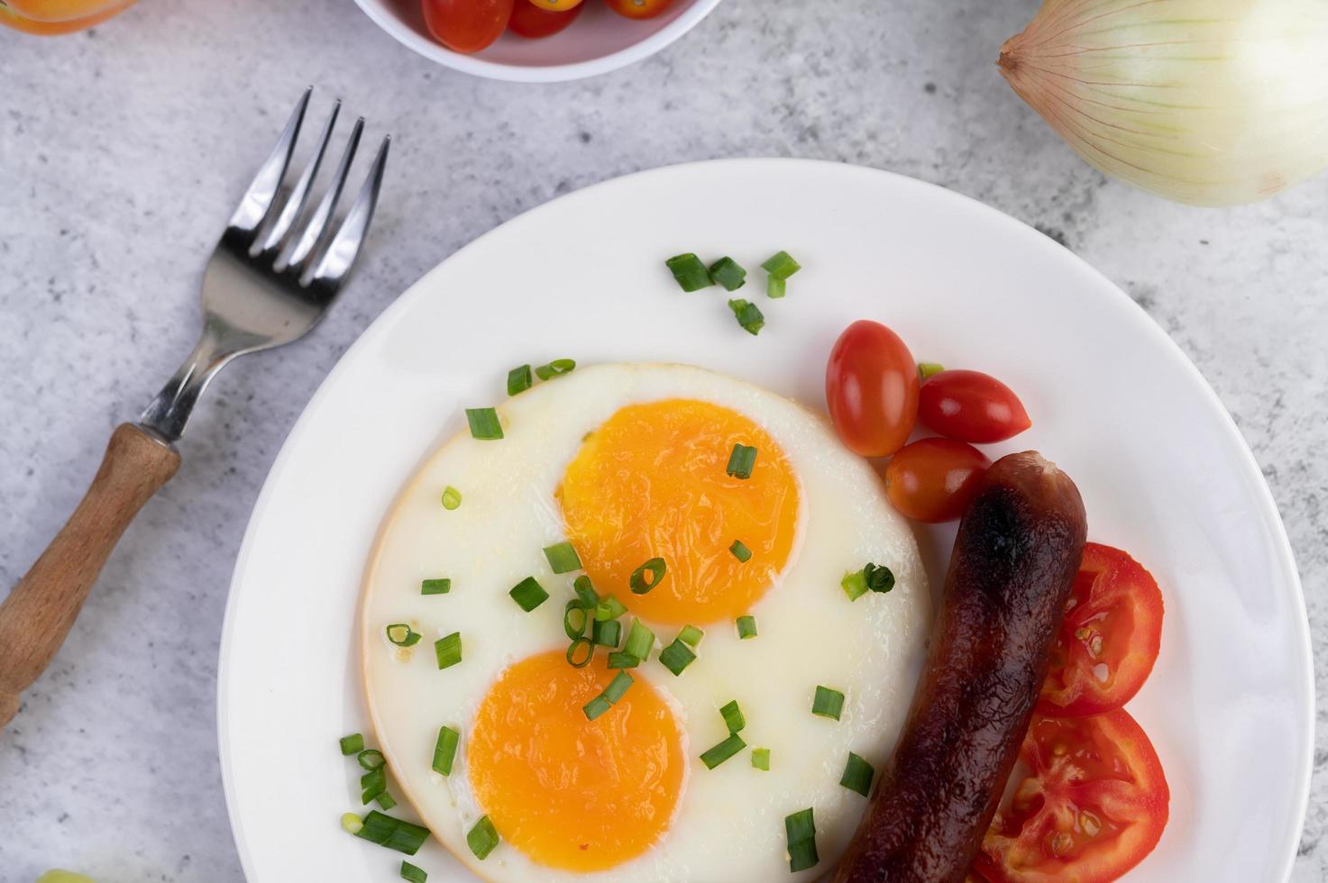 prato de café da manhã com ovos fritos, tomate, linguiça chinesa e cogumelos foto