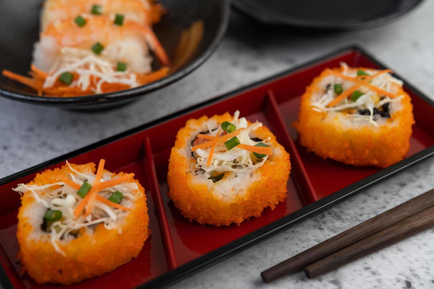 sushi banhado com molho e pauzinhos foto