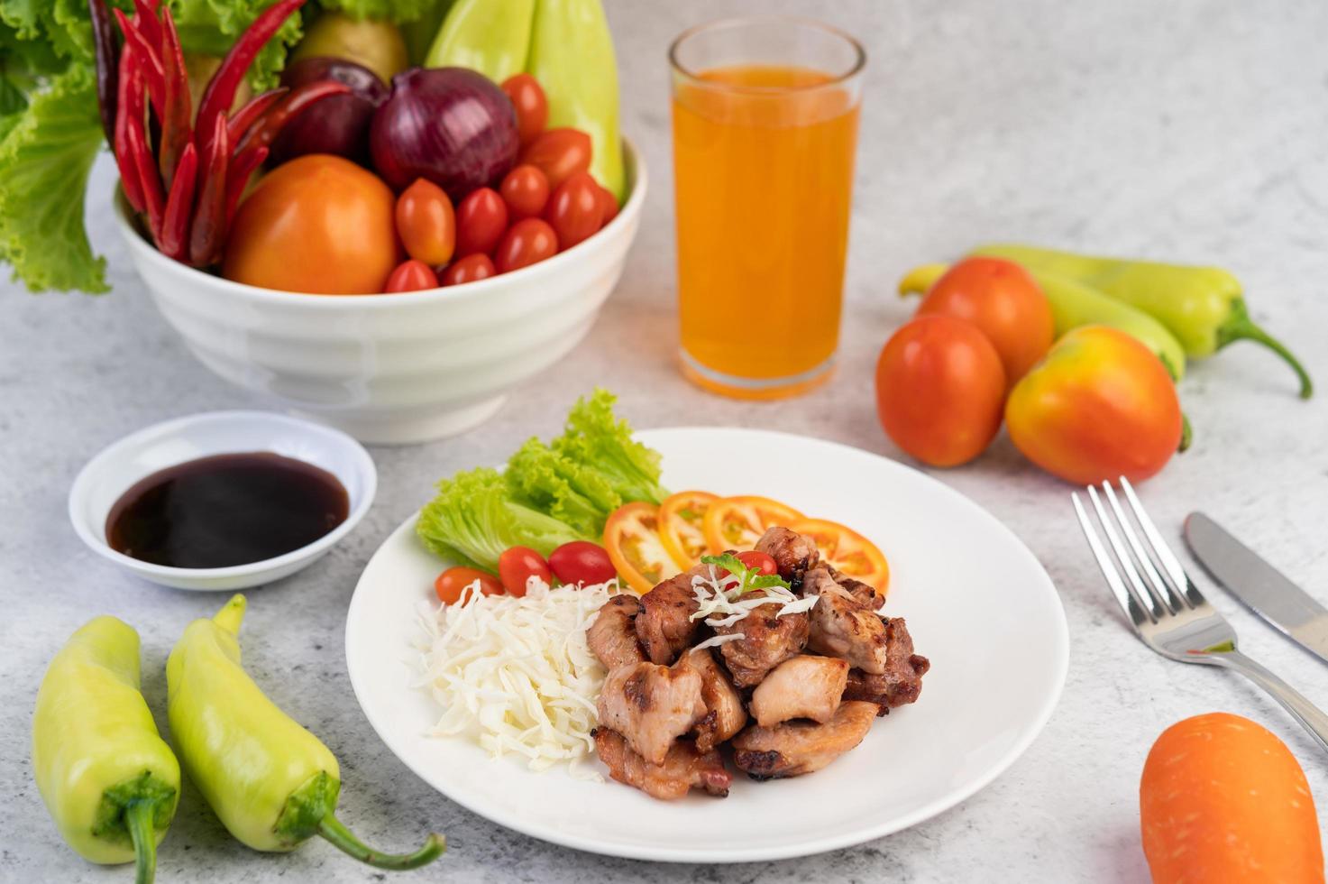 Costeleta de porco grelhada com tomate e salada foto