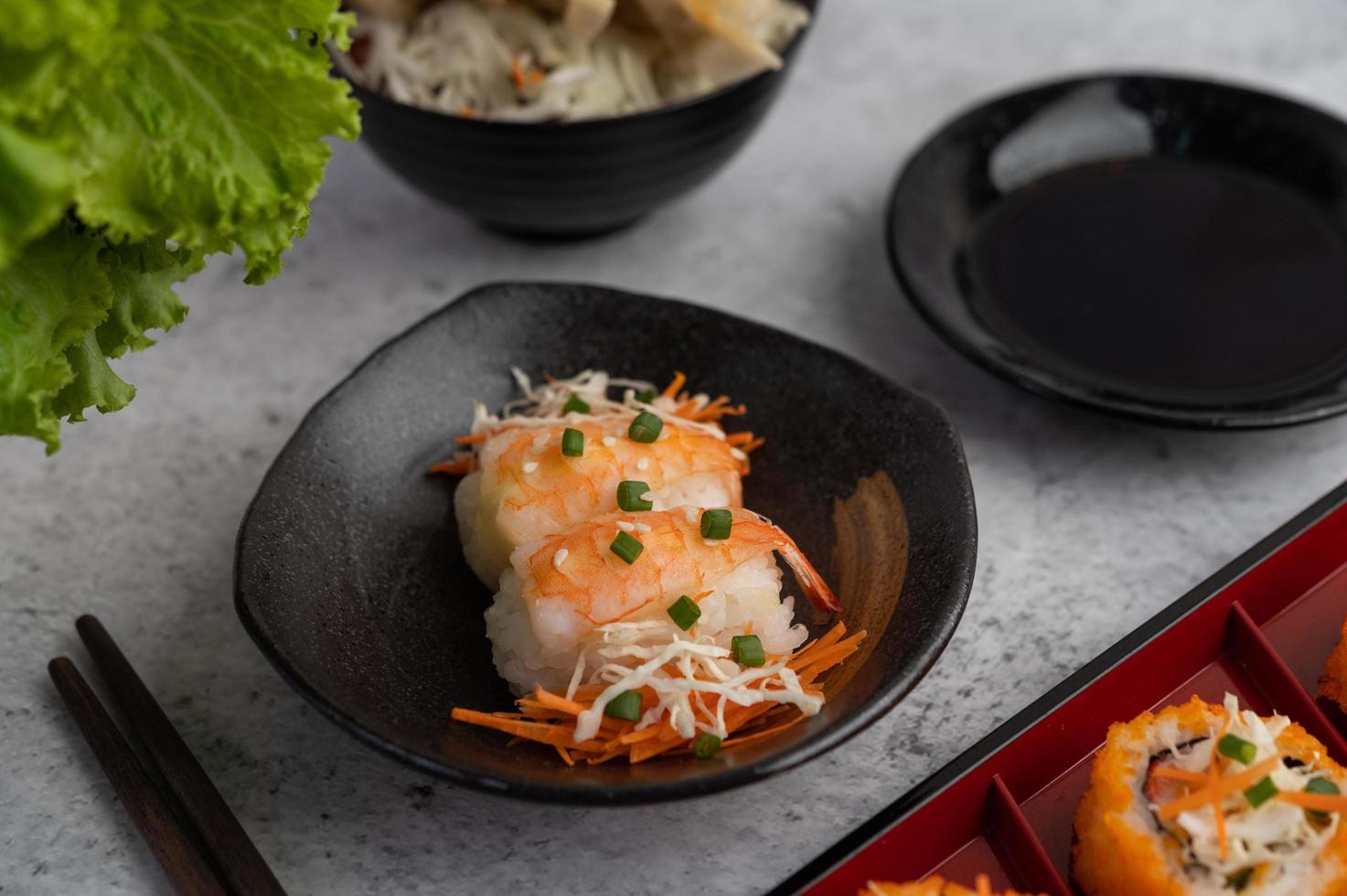 sushi banhado com molho e pauzinhos foto