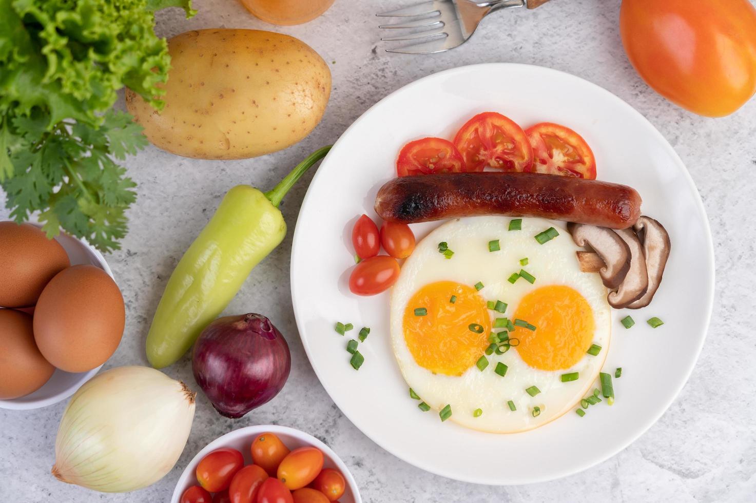 prato de café da manhã com ovos fritos, tomate, linguiça chinesa e cogumelos foto