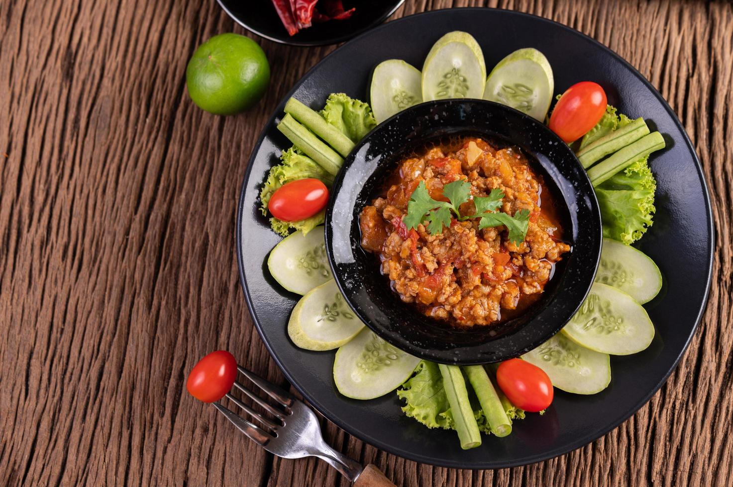 tigela de porco doce com pepino, feijão comprido e tomate foto