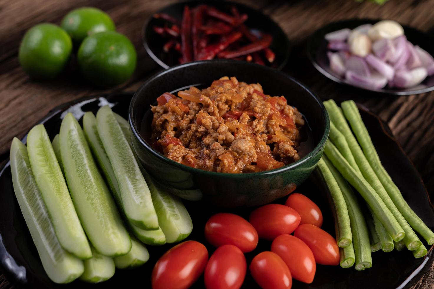 porco doce com pepino, feijão comprido, tomate e acompanhamentos foto