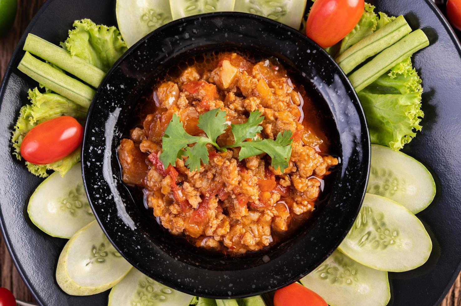 porco com pepino, feijão comprido, tomate e acompanhamentos foto