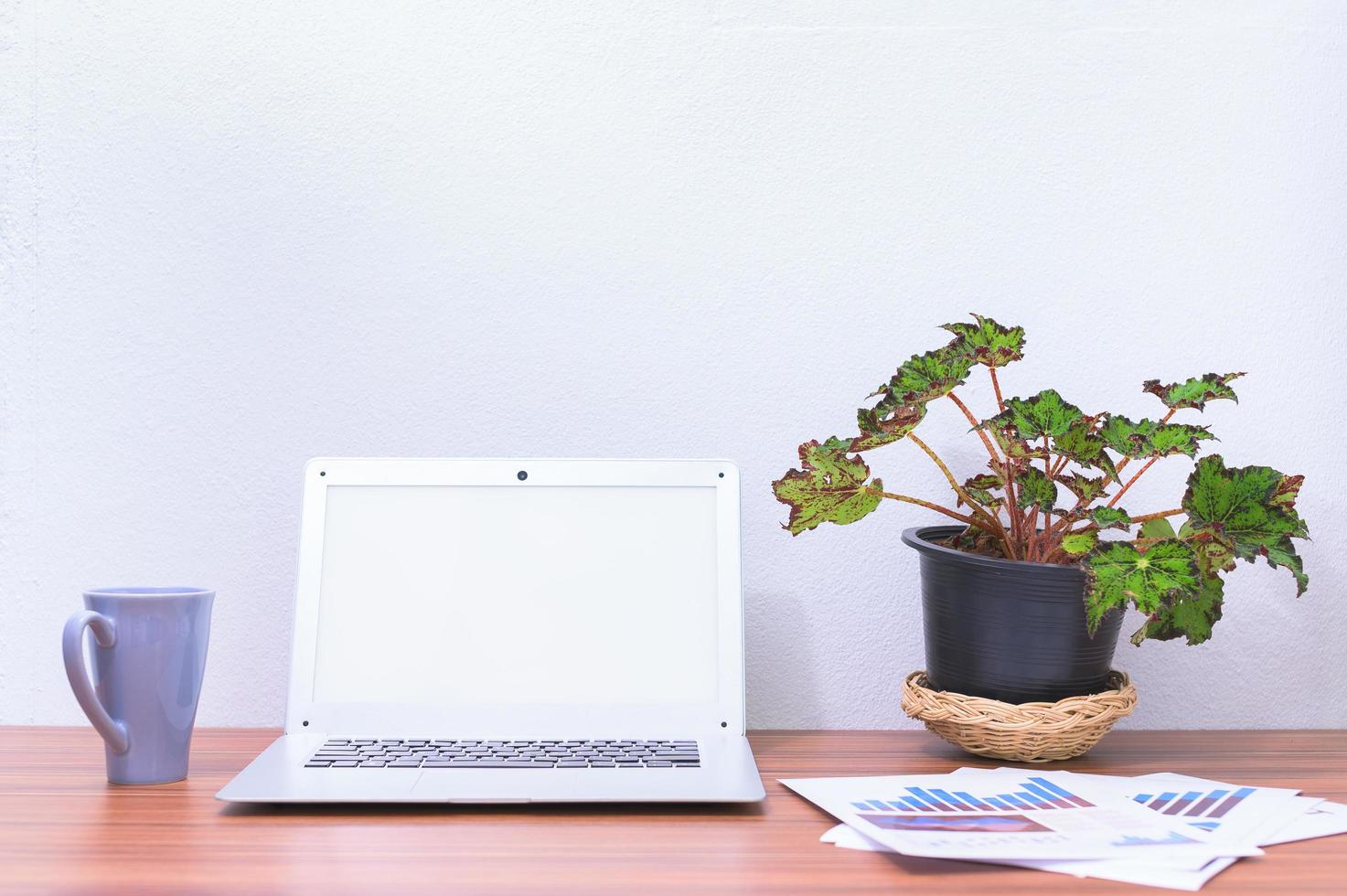 laptop e flores na mesa foto