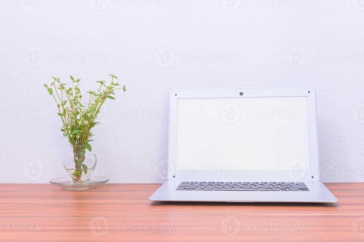 laptop e flor na mesa foto