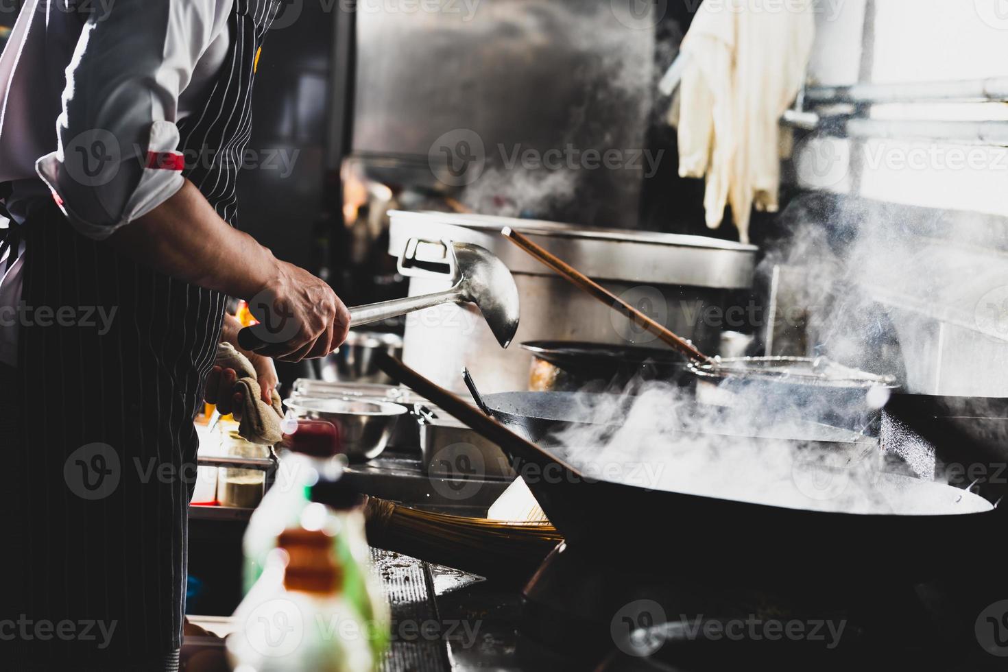 chef fazendo refogado em uma wok foto