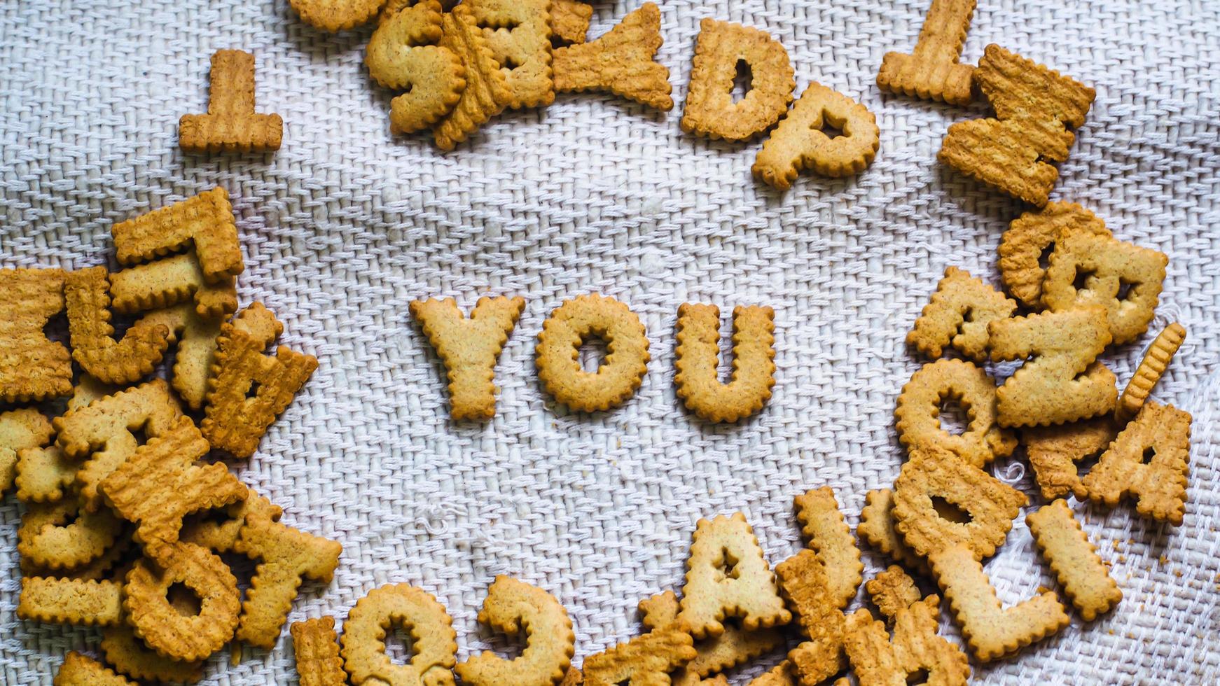 encontrar cookies de conceito na forma de uma perspectiva de alfabeto .happy de biscoitos caseiros em fundo branco escuro. conceito de cookies felizes. foto