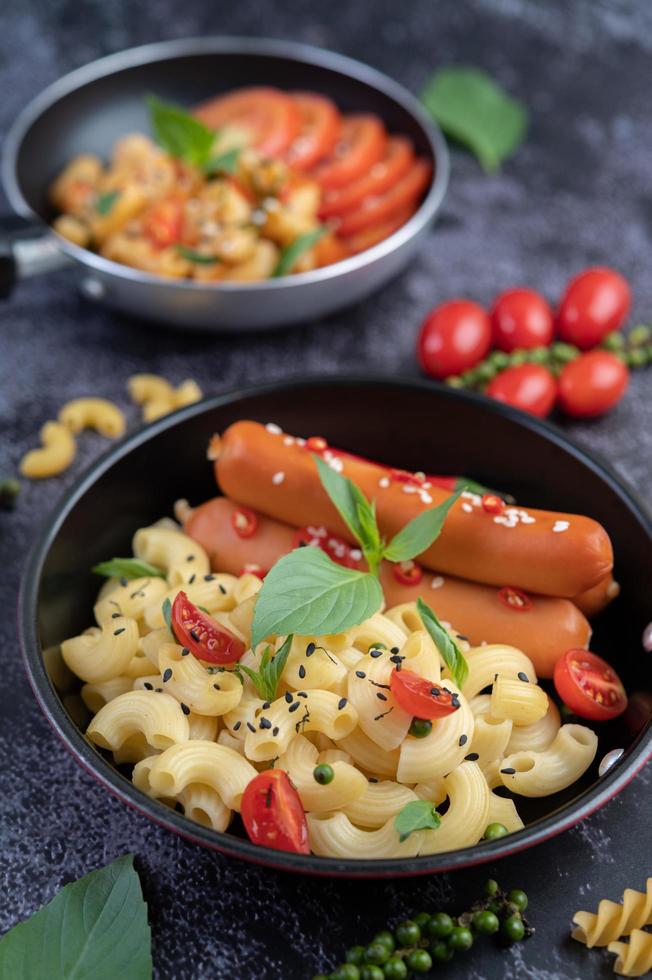 macarrão frito com salsicha em uma frigideira foto