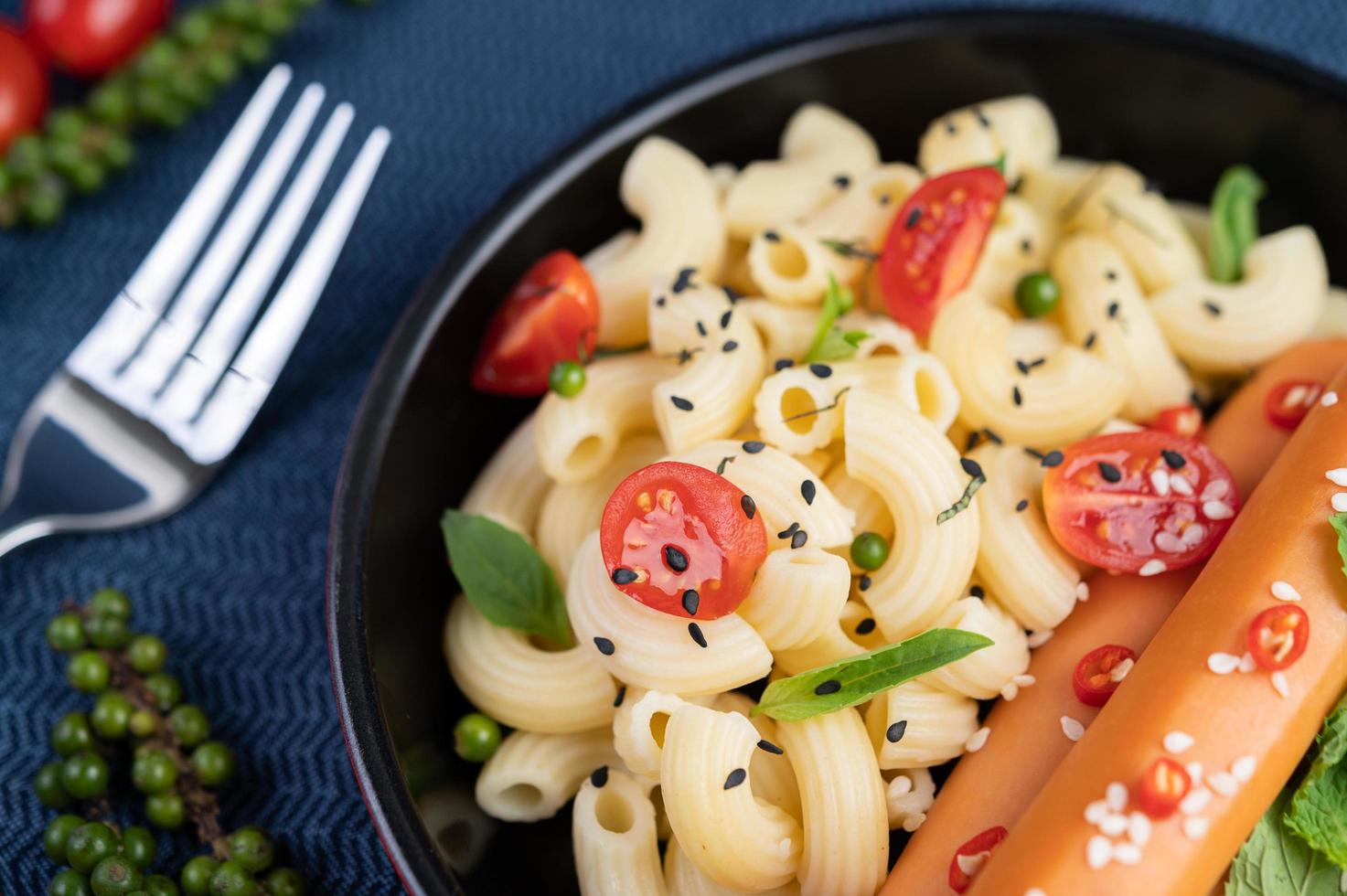 macarrão frito com salsicha em uma frigideira foto