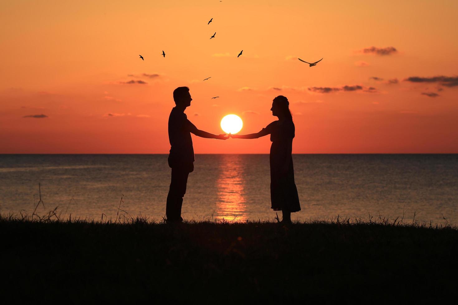 silhueta de um casal ao pôr do sol foto