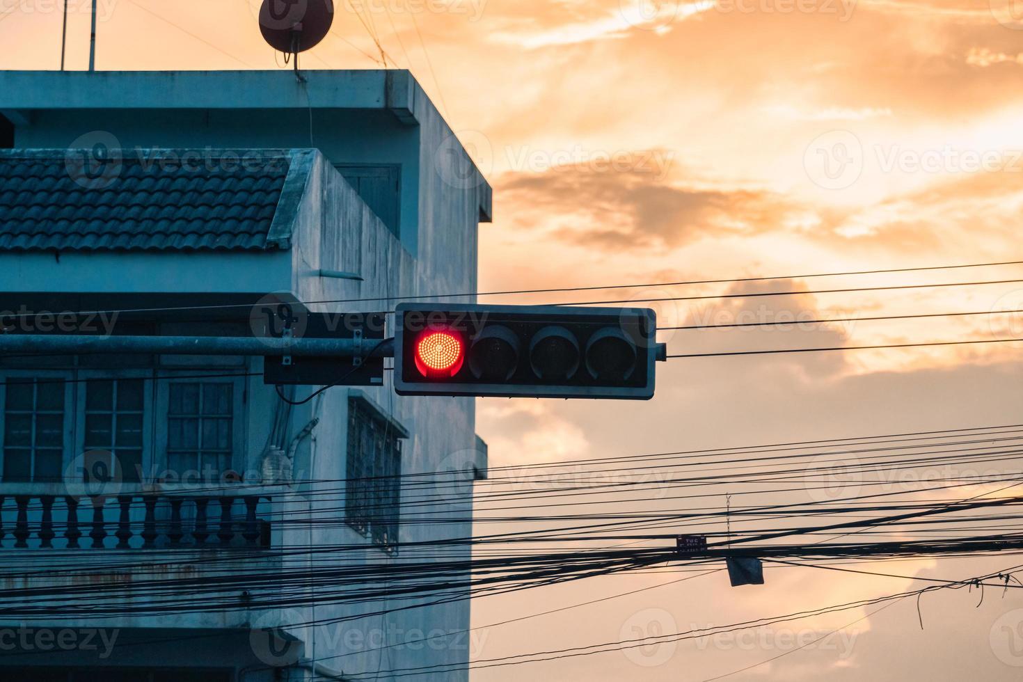 semáforo com sinnal vermelho para parada de carro e construção e cabo, fio foto