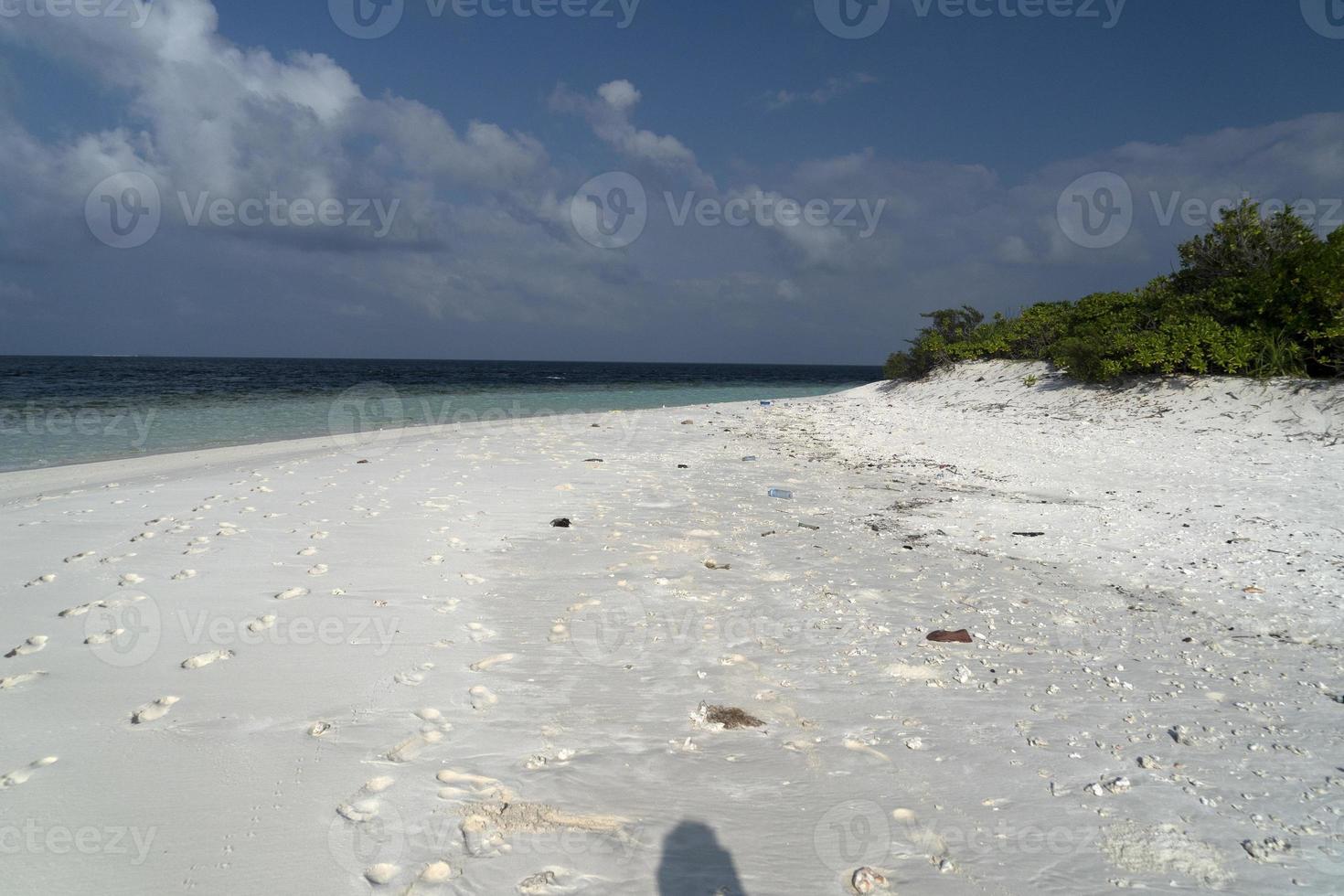 lixo na praia de areia paradisíaca de ilha tropical foto