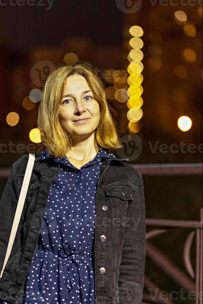 retrato de uma jovem em uma cidade à noite em uma noite de verão. luzes da cidade foto