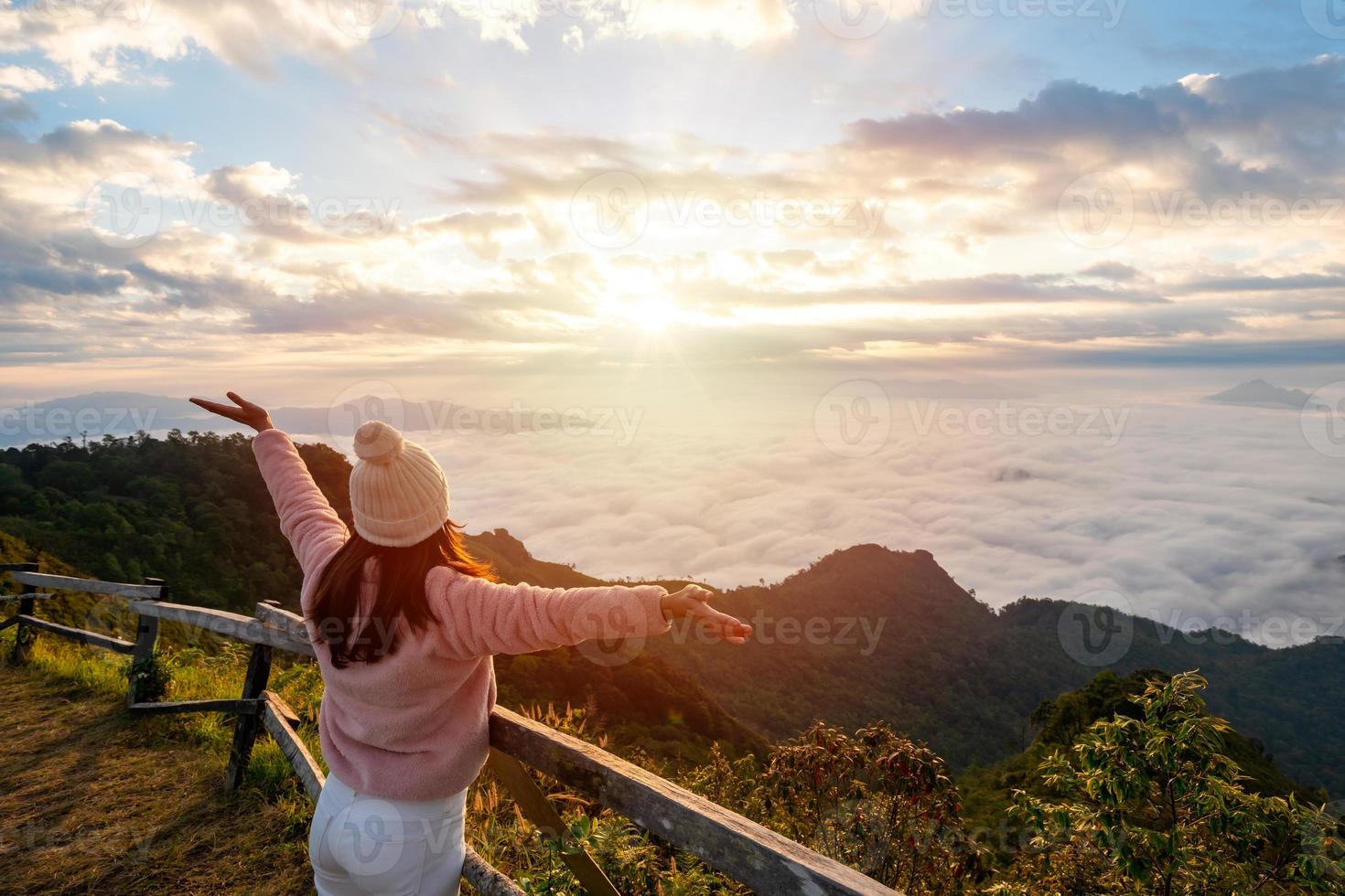 viajantes jovens olhando para o nascer do sol e o mar de névoa na montanha pela manhã, conceito de estilo de vida de viagem foto