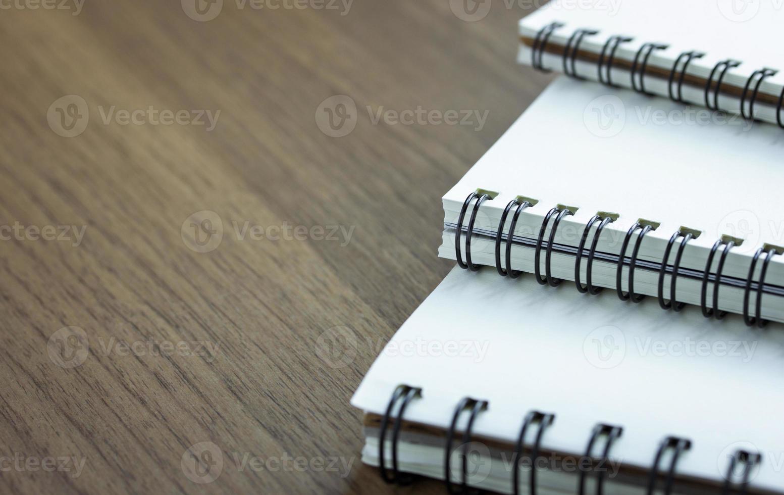 pilha de caderno espiral na mesa de madeira foto