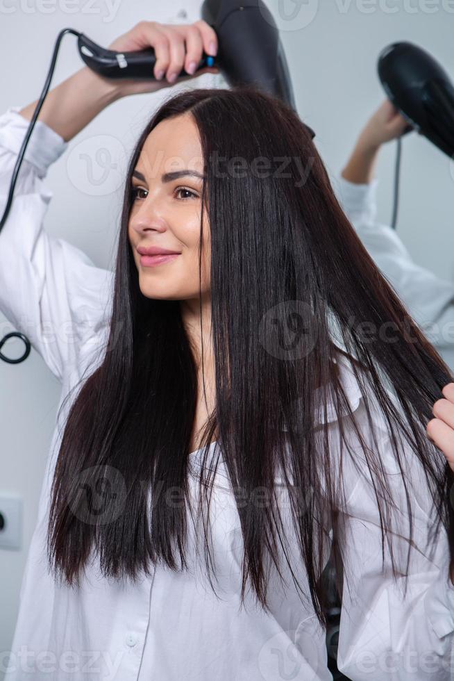 mulher jovem e bonita usando secador de cabelo no salão de cabeleireiro.  close-up do cabelo da mulher no salão de beleza, conceito de penteado  19576794 Foto de stock no Vecteezy