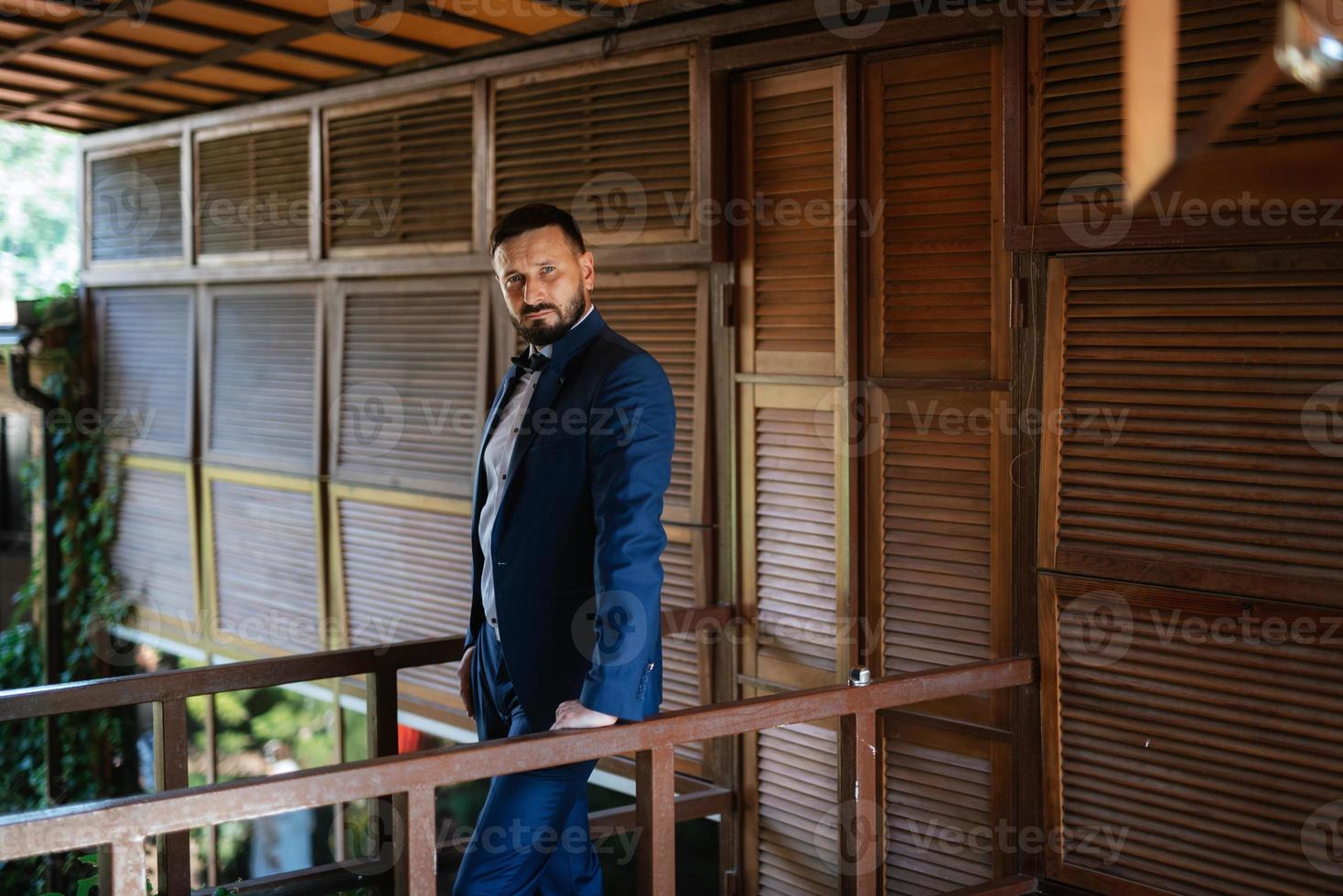 retrato de um noivo com barba em um terno azul foto