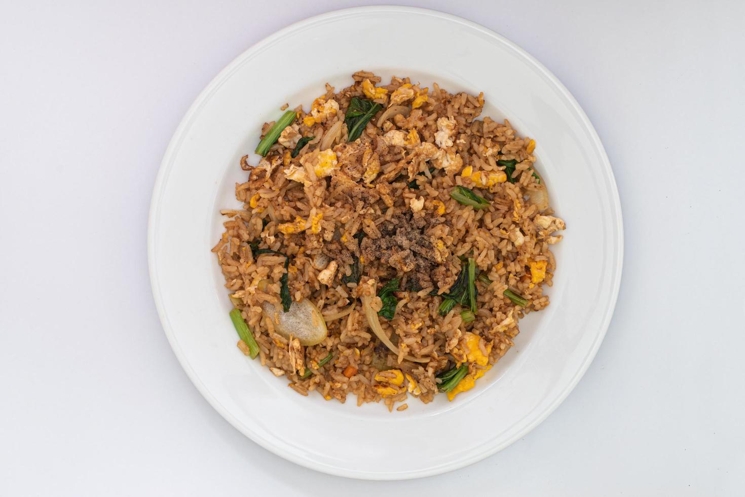 arroz frito simples com ingredientes simples, arroz, ovo estrelado, cebola, cenoura e legumes. arroz frito no prato branco isolado no fundo branco. estilo asiático de comida simples. foto