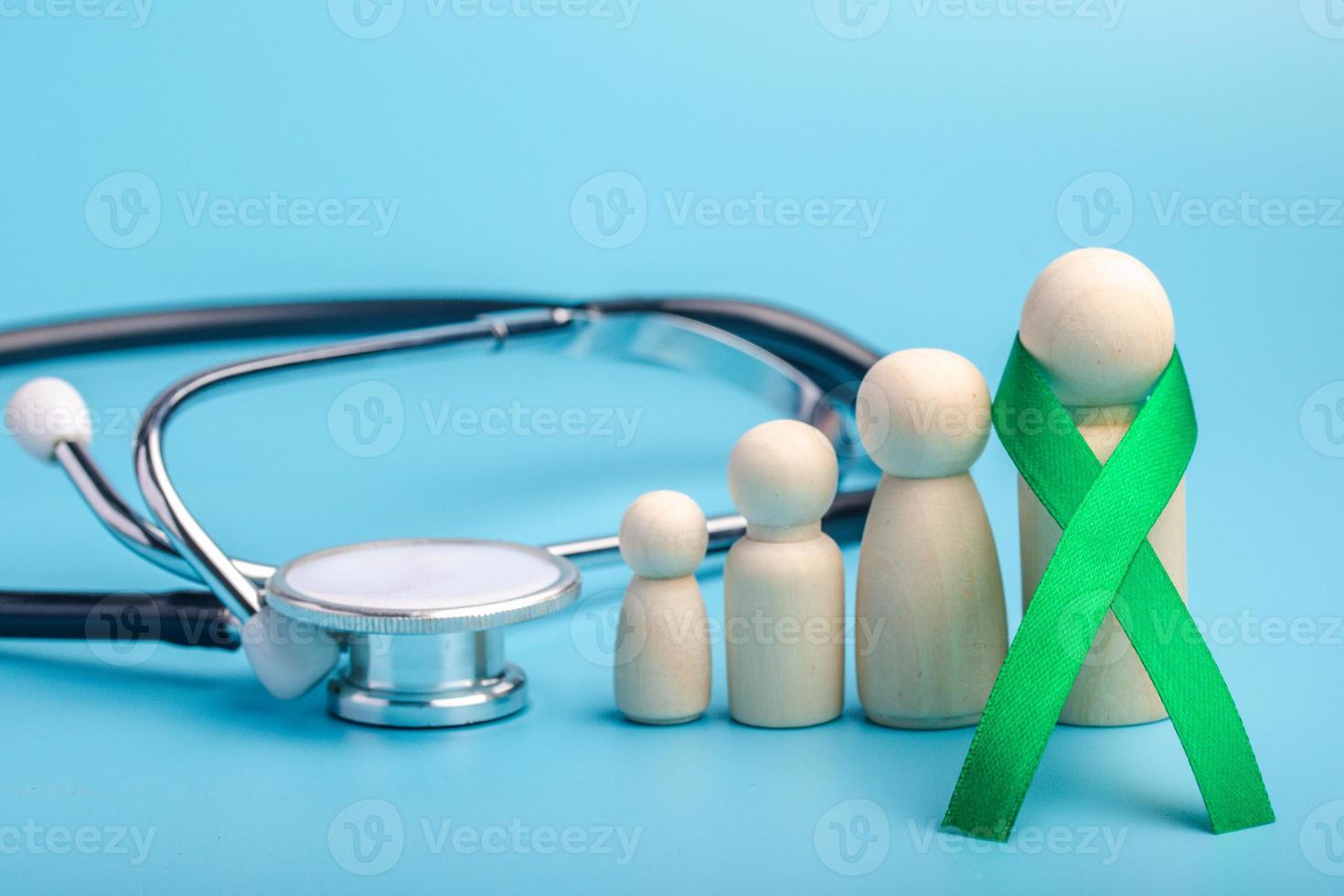 fita verde e conceito de stethoscope.treatment para câncer de ovário e câncer cervical. foto