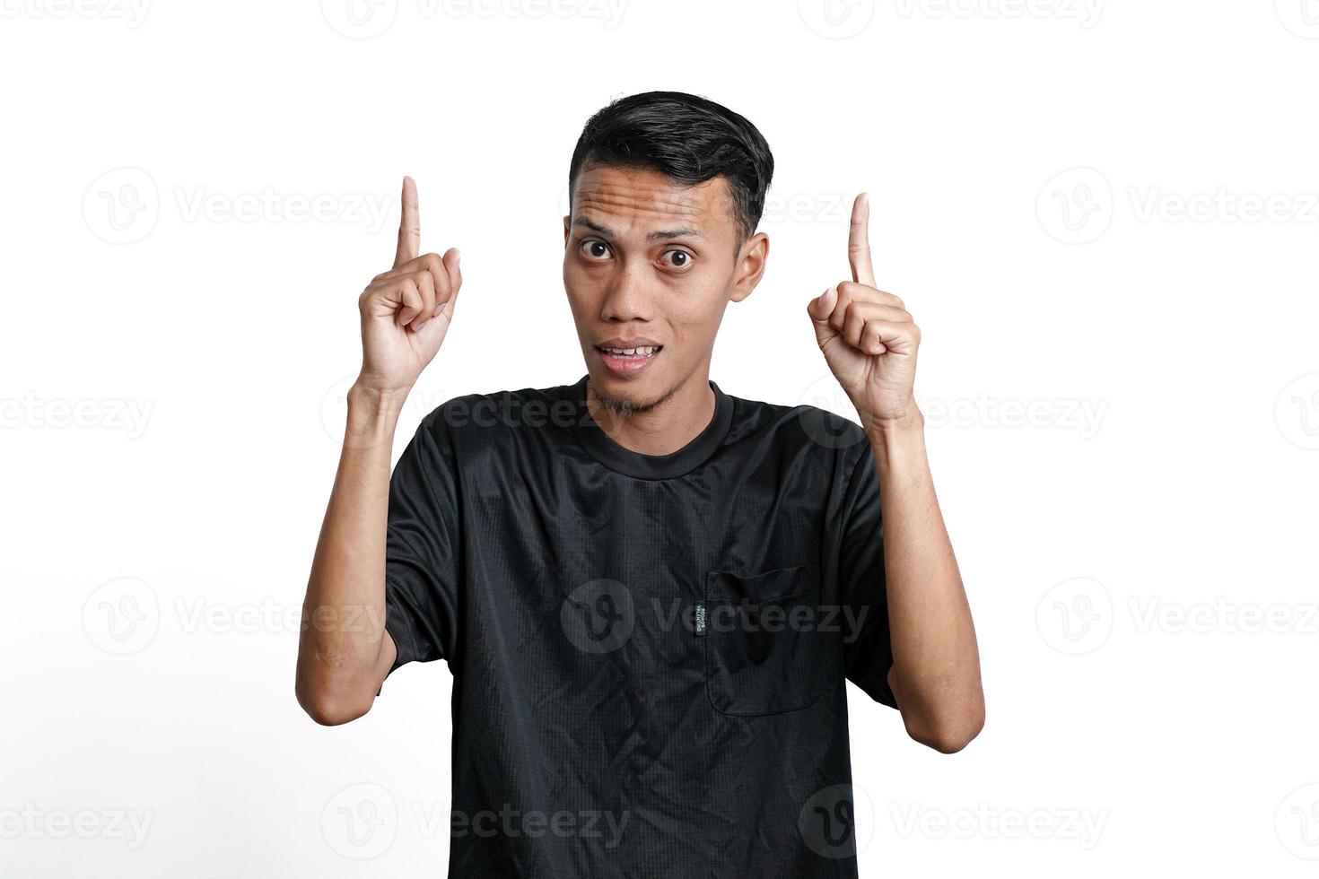 homem asiático animado vestindo camiseta preta de treinamento, apontando para copiar o espaço. isolado por fundo branco foto