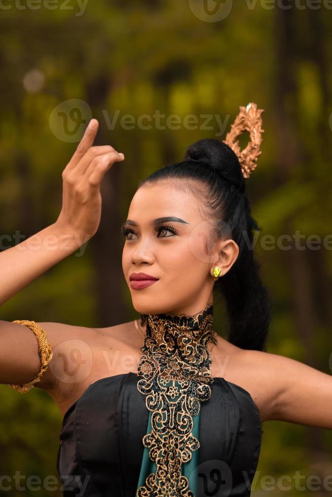 retrato de uma mulher balinesa com bela maquiagem e cabelo preto amarrado em uma expressão facial corajosa foto