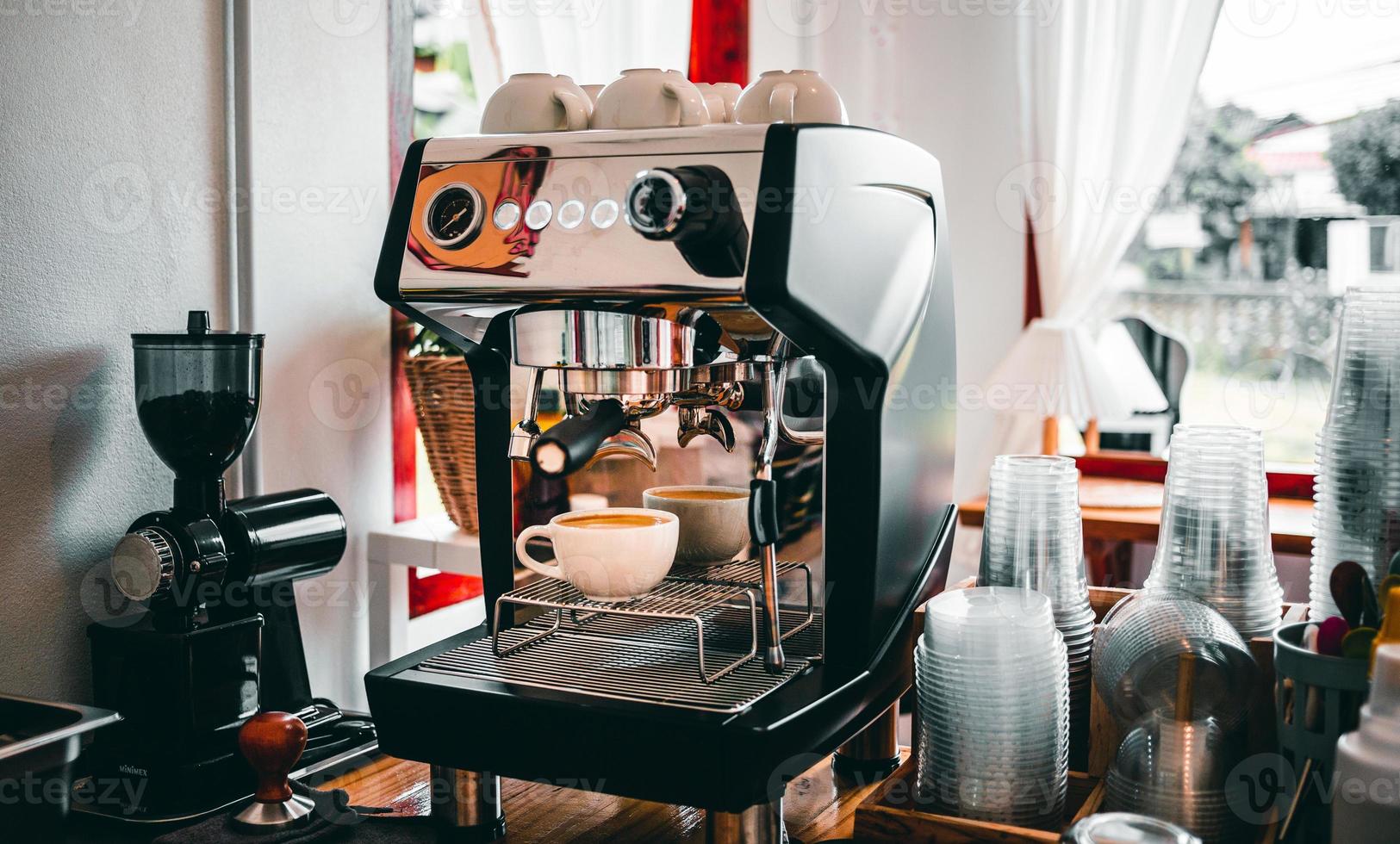 extração de café da máquina de café com um porta-filtro despejando café em uma xícara, café expresso saindo da máquina de café na cafeteria foto