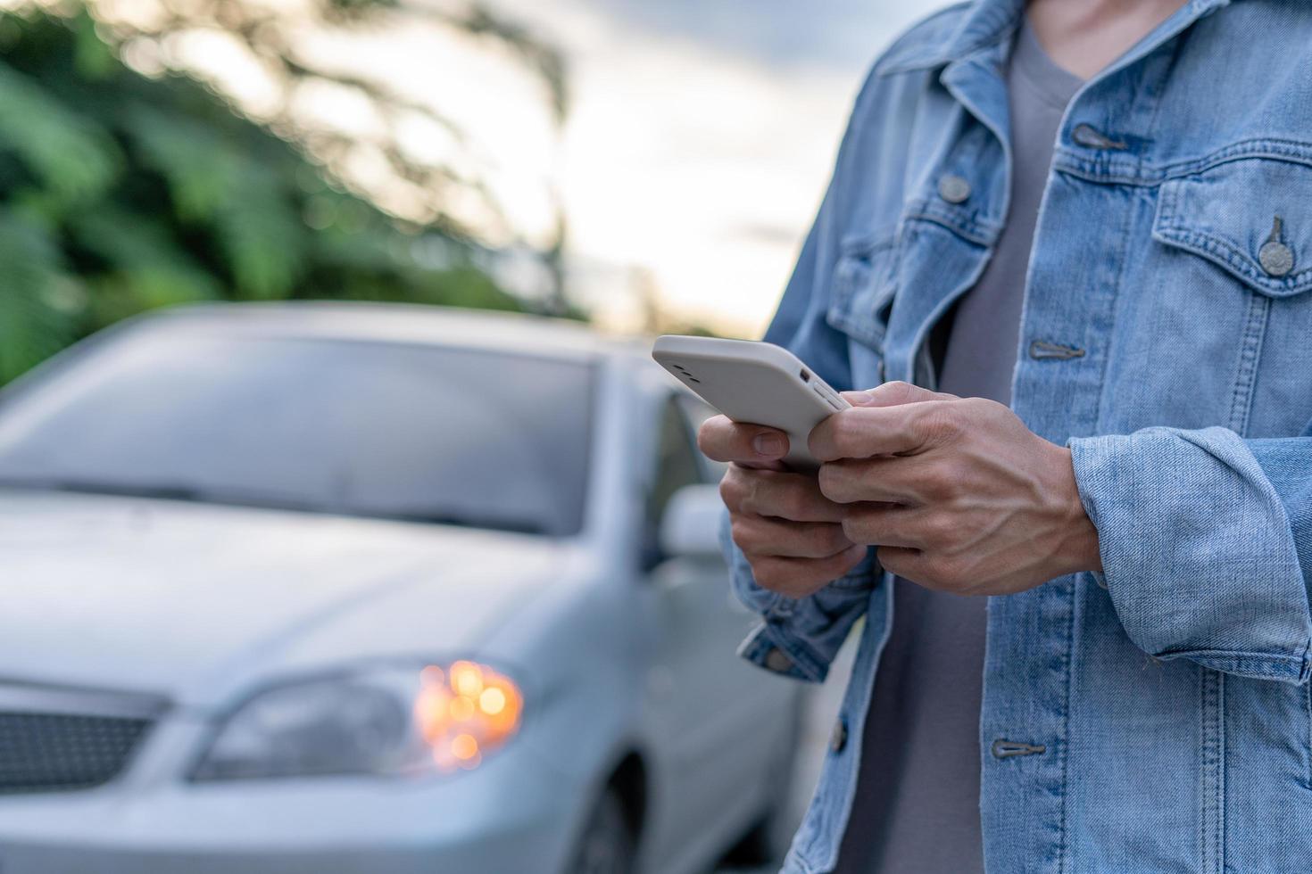 segurança de emergência. homem está discando um telefone celular para um número de emergência devido a uma avaria de carro na floresta. a manutenção do carro antes da viagem aumenta a segurança contra acidentes. foto