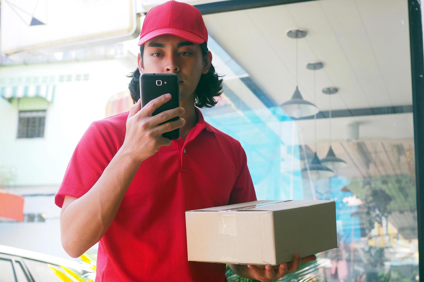 o jovem enviou o produto para buscar as informações do cliente pelo smartphone. entrega rápida foto