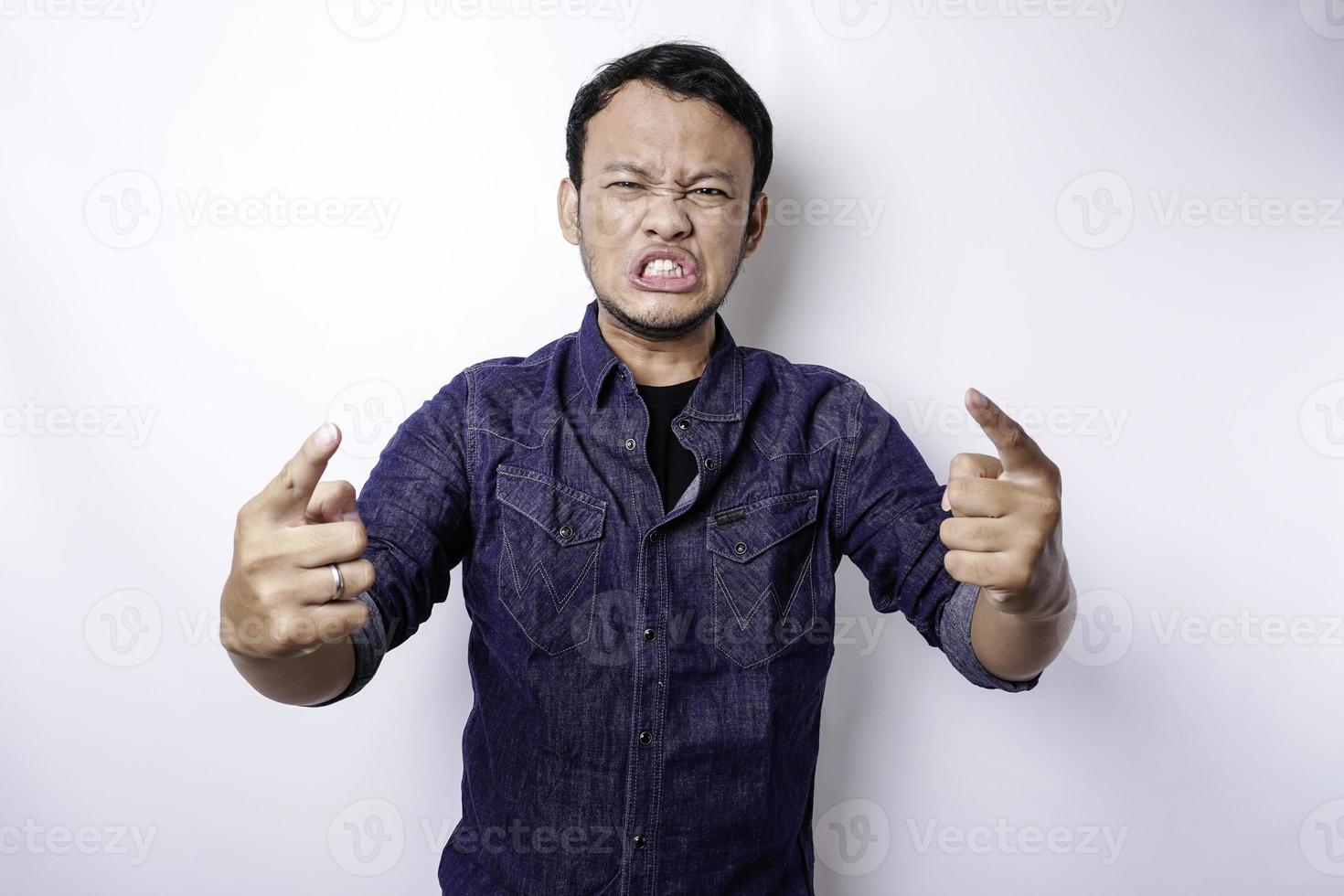 o rosto zangado e louco do homem asiático em fundo branco isolado de camisa azul. foto
