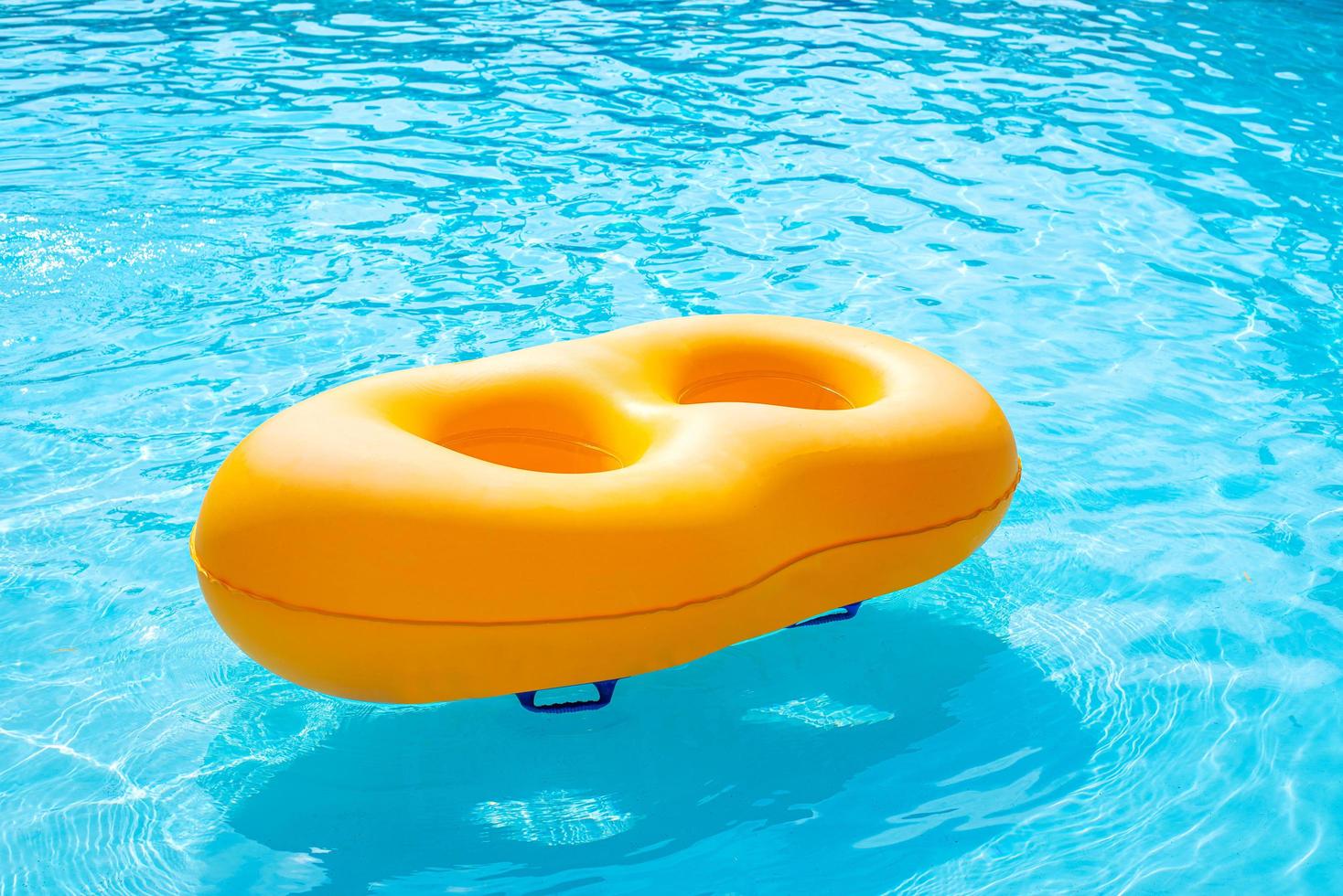 anel de borracha amarelo flutuando na piscina foto