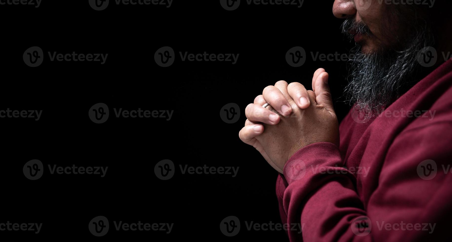 mãos postas em oração no conceito de igreja para fé, espiritualidade e religião, homem rezando pela manhã. mão de homem com Deus rezando. pessoa homens cristãos que têm fé em jesus adoram no escuro. foto